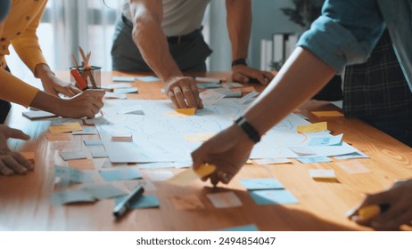 Close up of developer team using mind map to brainstorm idea. Top view of skilled group of business people working together writing marketing strategy by using markers and sticky notes. Symposium. - Powered by Shutterstock