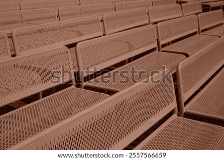 Close diagonal view of rows of metallic benches in Mocha color of the year. San Diego, Balboa park