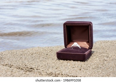 Close Up Of A Diamond Silver Ring In A Small Brown Box On Sand At Beach In Bali, Indonesia. For Anniversary, Relationship And Love Concept. No People. Copy Space.