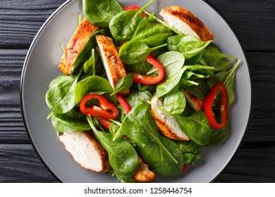 Close Up Of A Dietary Salad Of Fresh Baby Spinach, Chicken Breast And Bell Pepper On A Plate On The Table. Horizontal Top View From Above
