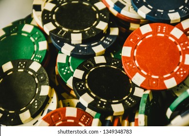 Close Up Of Different Color Casino Poker Chips Background. Many Old Poker Chips. Game Gambling And Entertainment Concept. Subject Is Blurry When Viewed At Full Resolution.