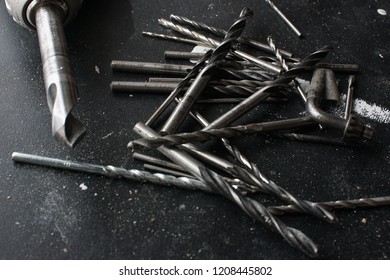 close up of different sized drill bits on a black back ground