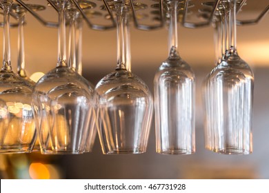 Close Up Of Different Sized Wine Glasses Hanging From A Bar Rack