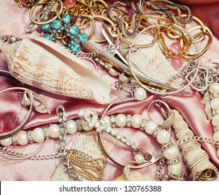 Close Up Of Different Women Accessories And Jewelery On Pink Fabric