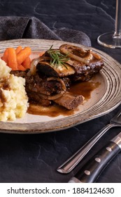 Close Up A Dinner Plate Of Braised Short Ribs With Mashed Potatoes And Baby Carrots Ready For Eating.