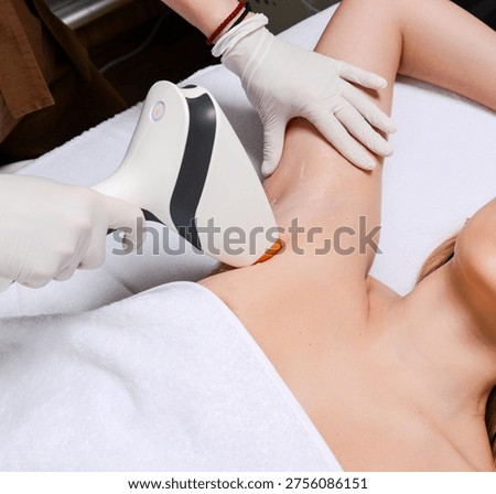 Close up of diode laser applicator on female armpit. Macro shot of laser hair removal head touching woman skin with protective gel during session.