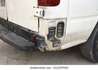 Close Up Of Dirty White Van With Damaged Rear End Tail Gate