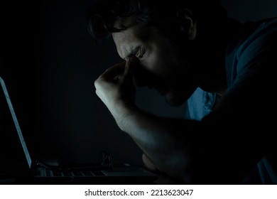 Close Up Of Disgusted Face Of Shocked Man Looking At Laptop At The Night Time	