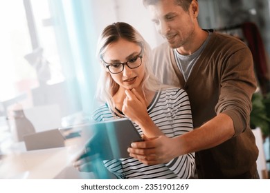 Close up diverse colleagues using tablet together, discussing online project - Powered by Shutterstock