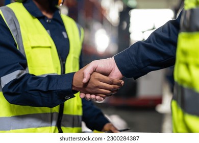 Close up of diverse industrial worker doing handshake in manufactory. Attractive industry factory engineer people working, enjoy partnership agreement after negotiations for business deal at warehouse - Powered by Shutterstock