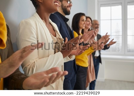Close up of diverse multiracial businesspeople clap hands meet welcome coach or presenter at briefing. Multiethnic employees applaud show acknowledgement or appreciation at business training.