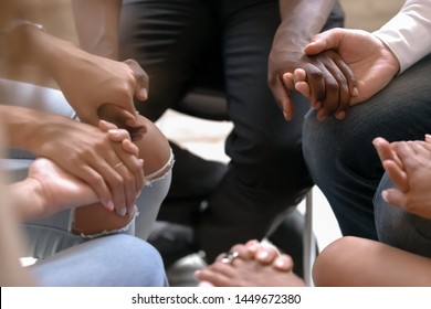 Close up diverse people sitting on chairs in circle, holding hands at group therapy counselling session, psychological help, trust and support, drug alcohol addiction treatment rehab concept