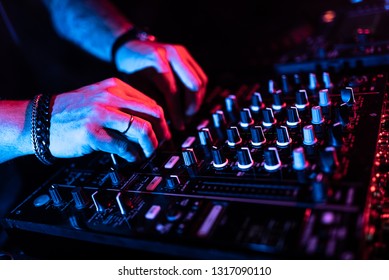 Close Up Of DJ Hands Mixing Music On A Table. DJ In A Night Club.