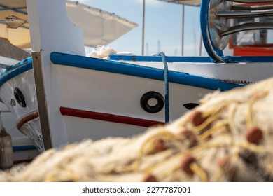 Close up of a docked fishing boat. Fishing nets in the foreground, out of focus.  - Powered by Shutterstock