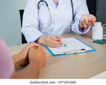 Close Up Of Doctor Cosoulting A Patiant In A Hospital. Bottel And Pill On The Table. Health Care And Medical Care Concept.