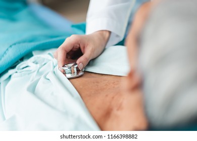 Close Up Doctor Hand Examining Old Asian Patient By Using Stethoscope At Man Chest