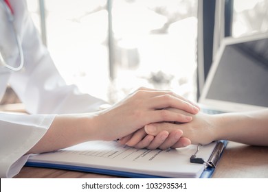 Close Up Of Doctor Hand Reassuring Her Female Patient At Hospital. Closeup Hands Of Medical Doctor Carefully Holding Patient's Hands. Kind Doctor Giving Real Support For Patient, Soft Focus.