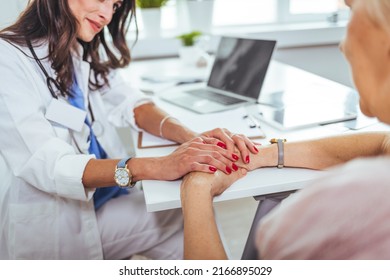 Close Up Of Doctor Hand Reassuring Her Female Patient At Hospital. Closeup Hands Of Medical Doctor Carefully Holding Patient's Hands. Kind Doctor Giving Real Support For Patient.