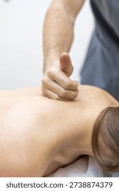 Close up of a doctor hand using deep pressure on back muscles in a rehabilitation center. Minimal background highlights focus, painrelief and recovery care.