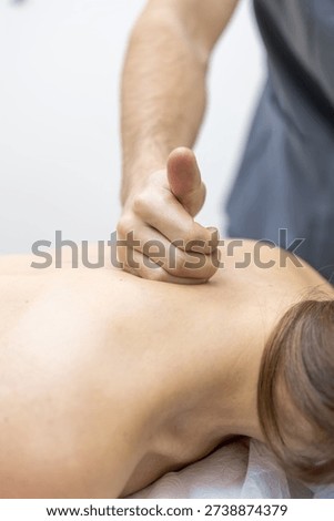 Close up of a doctor hand using deep pressure on back muscles in a rehabilitation center. Minimal background highlights focus, painrelief and recovery care.