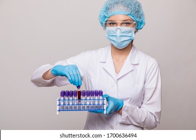 Close up doctor hands with blood testing tube isolated on gray background