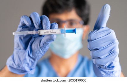 Close up of doctor hands with covid-19 booster shot syringe showing thumbs up - concept showing of recommendation of 3rd dose vaccination for immune weakened people. - Shutterstock ID 2030199008