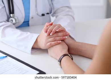 Close up of doctor hands reassuring her female patient. Medicine, help and health care concept - Powered by Shutterstock