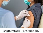 close up doctor holding syringe and using cotton before make injection to patient in medical mask. Covid-19 or coronavirus vaccine