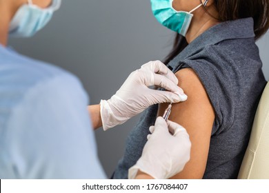 close up doctor holding syringe and using cotton before make injection to patient in medical mask. Covid-19 or coronavirus vaccine - Shutterstock ID 1767084407