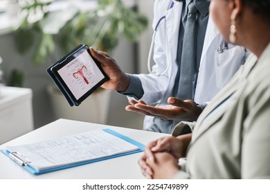 Close up of doctor holding tablet with female reproductive health charts