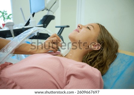 Close up of doctor making thyroid sonogram for kid. Pediatric ultrasound scan. Child ultrasound. Pediatrician scanning neck. Ultrasound examination of lymph nodes. Childhood diseases