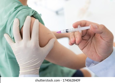 Cierre de un médico que realiza una vacunación en el hombro del paciente, Vacunación antigripal Inyección en el Brazo, coronavirus, enfermedad de la vacuna covid-19 preparándose para ensayos clínicos humanos vacuna de vacunación.