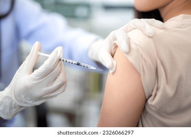 Close up of doctor making a vaccination in the shoulder of patient. coronavirus, Flu Vaccination Injection on Arm, covid-19 vaccine disease preparing for human clinical trials vaccination shot.