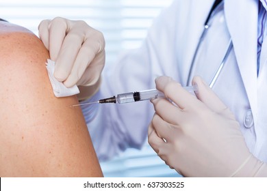 Close up of a Doctor making a vaccination in the shoulder of patient