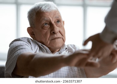 Close up of doctor or nurse hold hands help sick disabled mature 80s male patient in clinic or hospital, caregiver support ill weak senior 70s man in retirement house, elderly healthcare concept - Powered by Shutterstock