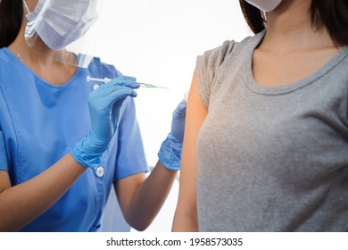 Close up doctor or nurse in medical mask holding syringe and using cotton before make injection to patient Covid-19 or coronavirus vaccine