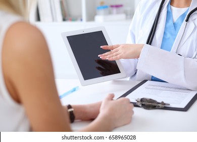 Close Up Of A Doctor And  Patient Hands While Phisician Pointing Into Tablet Computer Monitor