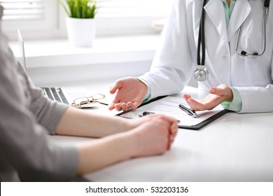 Close up of doctor and  patient  sitting at the desk near the window in hospital - Powered by Shutterstock