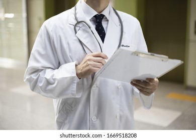 Close Up Of Doctor Reviewing Medical Chart