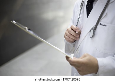 Close Up Of Doctor Reviewing Medical Chart