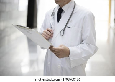 Close Up Of Doctor Reviewing Medical Chart
