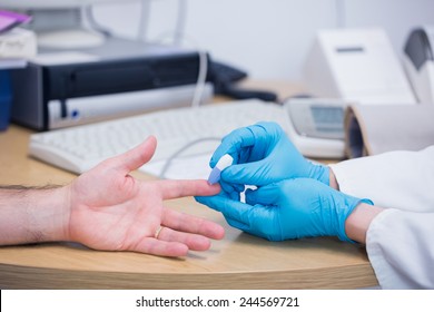 Close up of a doctor testing his patients blood at the hospital