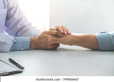 Close up of doctor touching patient hand for encouragement and empathy on the hospital, cheering and support patient, Bad news, medical examination, trust and ethics