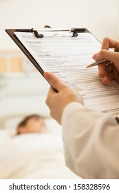 Close Up Of Doctor Writing On A Medical Chart 