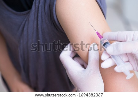 close up doctor's hand injecting for vaccination in the shoulder woman patient.Vaccine for protection HPV (Human Papillomavirus) infection.Vaccination for coronavirus treatment.Prevention infectious.