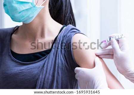 close up doctor's hand injecting for vaccination in the shoulder woman patient.Vaccine for protection HPV (Human Papillomavirus) infection.Vaccination for coronavirus treatment.