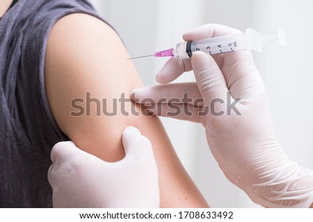 close up doctor's hand injecting for vaccination in the shoulder woman patient.Vaccine for protection HPV (Human Papillomavirus) infection.Vaccination for coronavirus treatment.