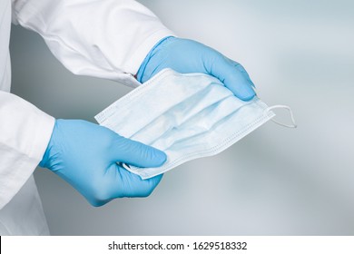 close up of doctor's hand with a medical face mask for protection against infection - Powered by Shutterstock