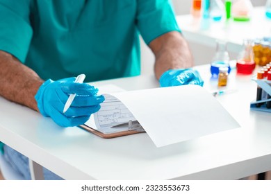 Close up of doctor's hands making notes on table