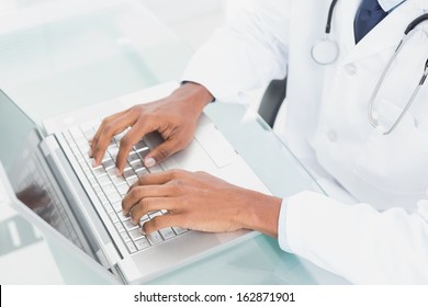 Close up of doctor's hands using laptop at medical office - Powered by Shutterstock